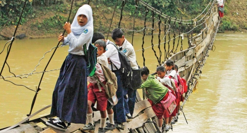 Deca u Indoneziji na putu do škole prelaze preko ruiniranog mosta | Foto: Reuters
