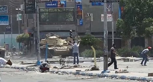 Demonstrant stoji ispred tenka sa podignutim rukama